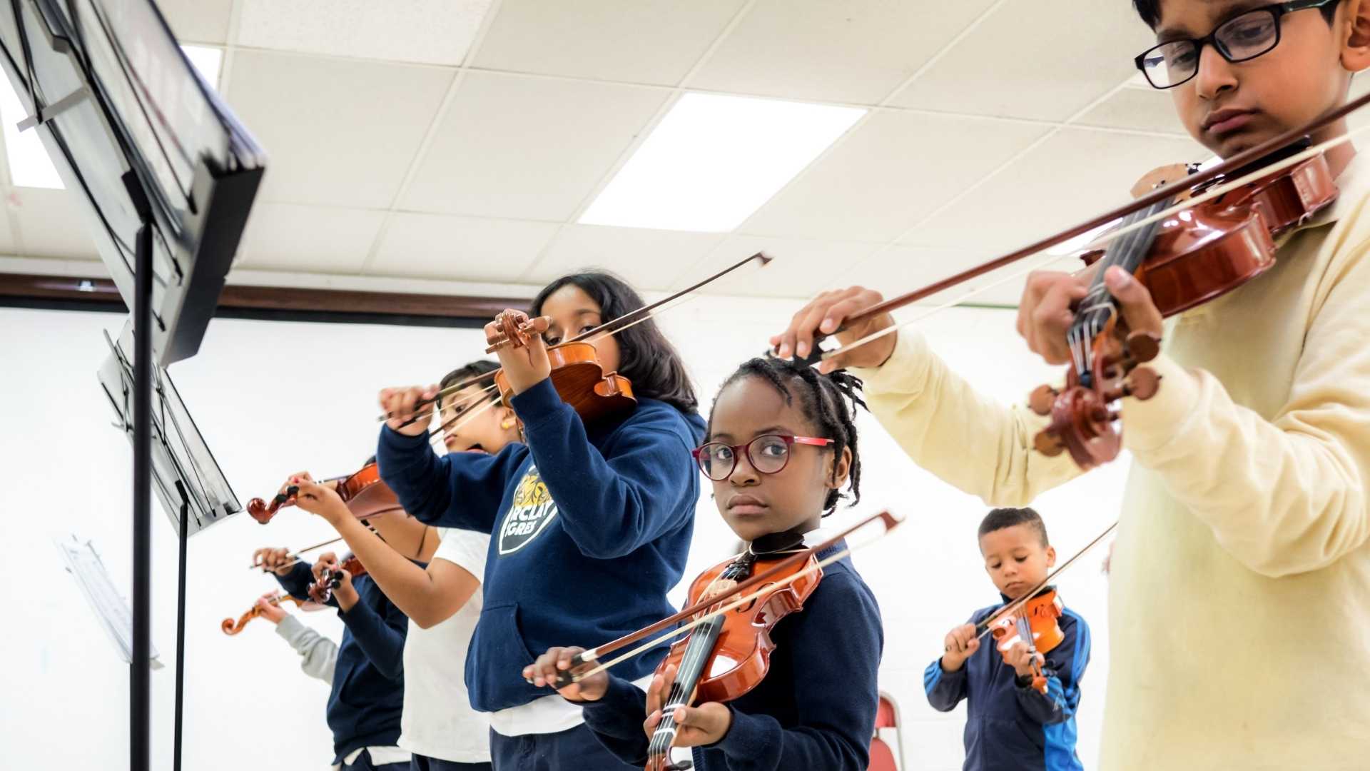 A group of kids playing violin